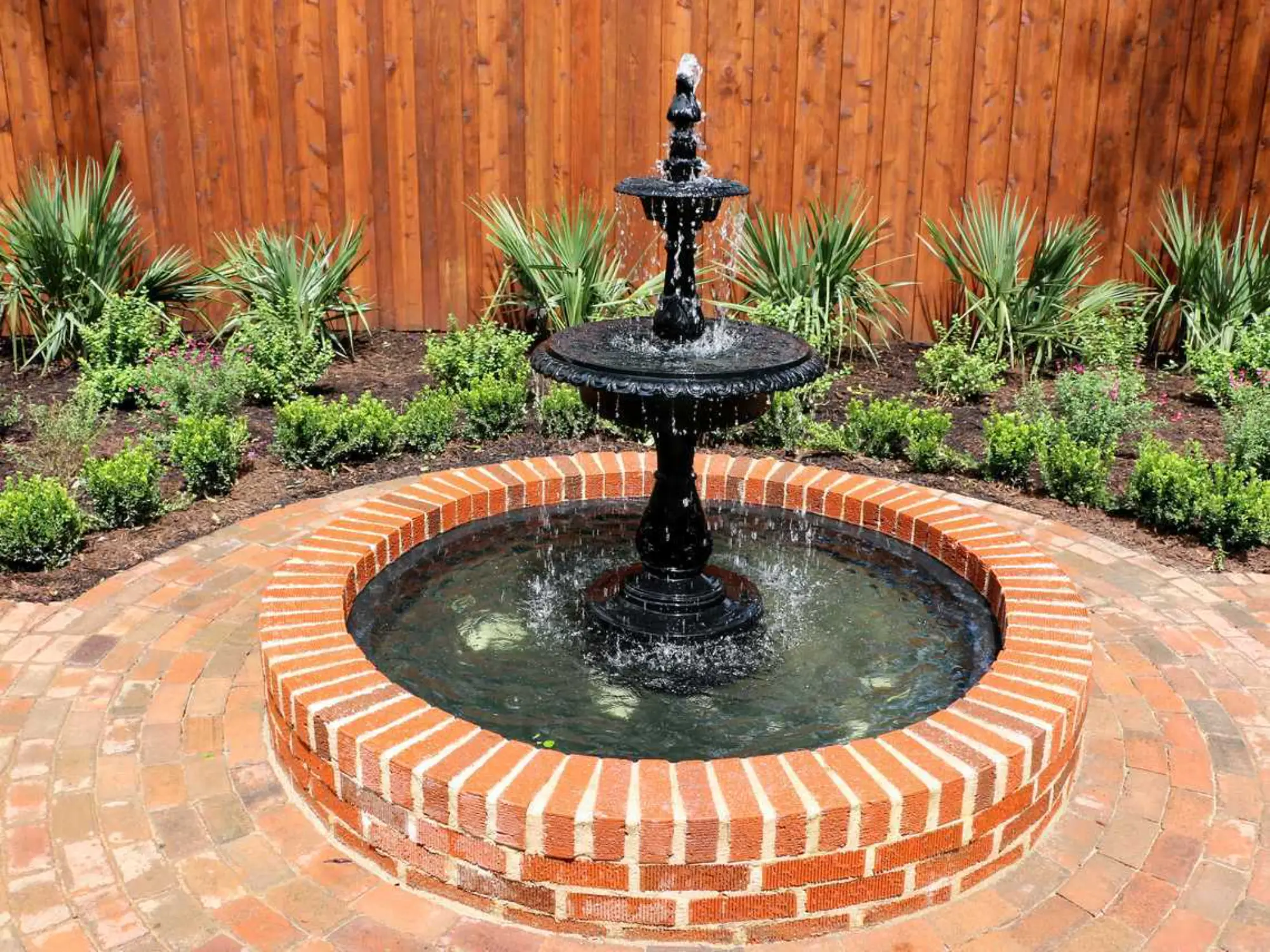 A circular brick patio features a central brick fountain, enhancing the outdoor ambiance.