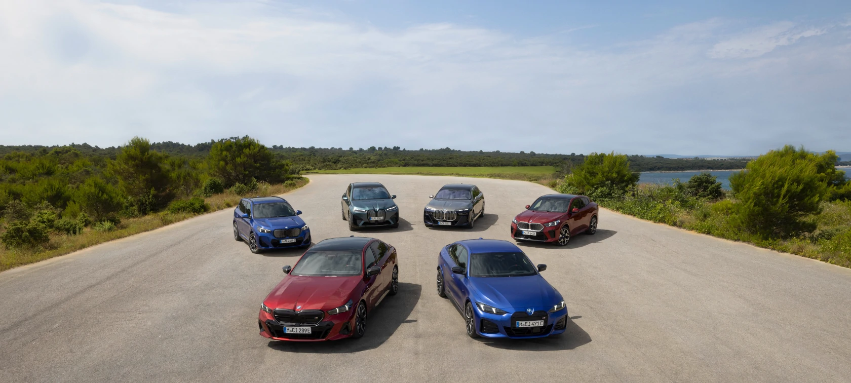 Reihe von BMW-Modellen auf einer Landstraße – Vielfalt und Fahrfreude im Autohaus BMW Köhler in Karlstadt