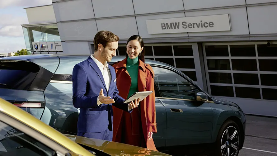 Kunden bei der Beratung vor einem BMW – Persönliche Betreuung im Autohaus BMW Köhler in Karlstadt