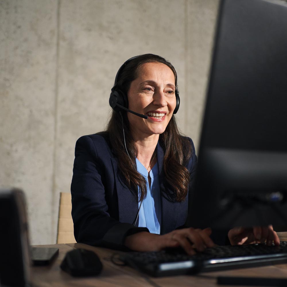Frau mit Headset vor einem Computer telefoniert bei BMW Köhler in Karlstadt