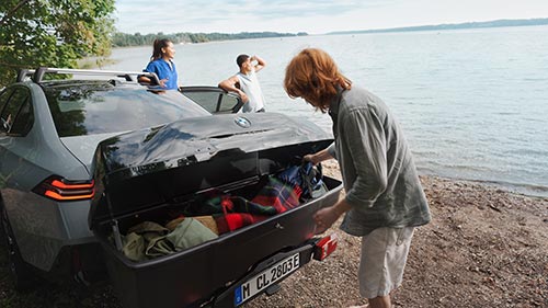 Familie packt den Kofferraum eines BMW am See – Flexibilität und Alltagstauglichkeit im Autohaus BMW Köhler in Karlstadt