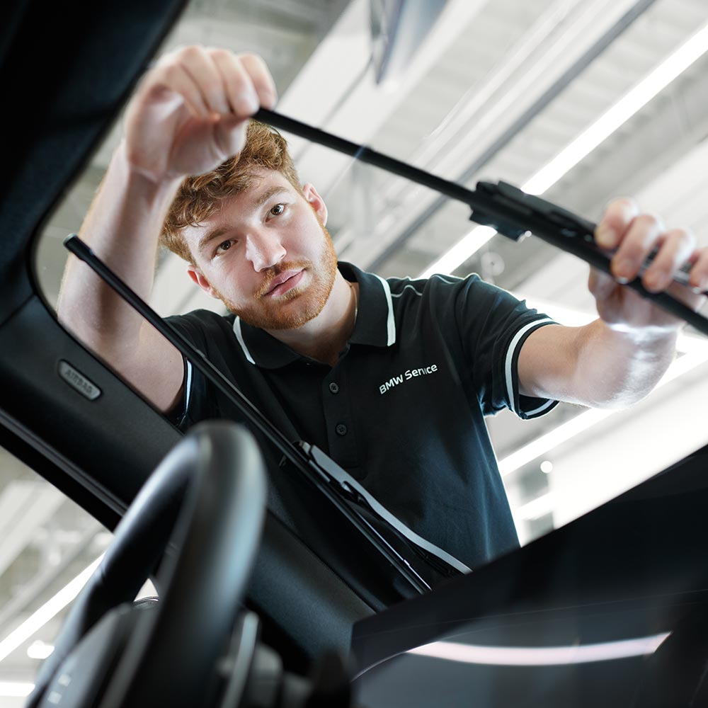 Mechaniker tauscht die Scheibenwischer eines BMW aus – Service und Pflege im Autohaus BMW Köhler in Karlstadt