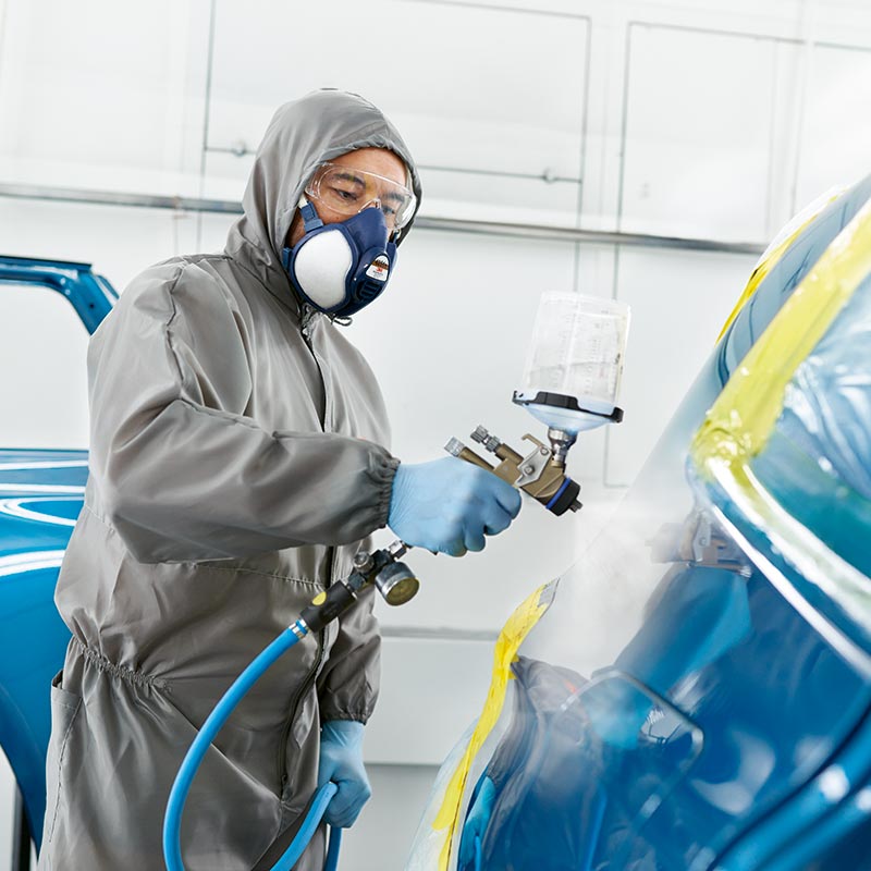 Mechaniker bei der Nutzung eines Lackiersprühgeräts – Präzision und Sorgfalt im Autohaus BMW Köhler in Karlstadt