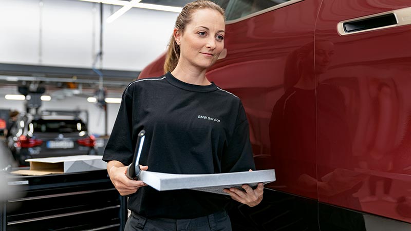 Mitarbeiterin überprüft Fahrzeugdetails – Expertise und Präzision im Autohaus BMW Köhler in Karlstadt