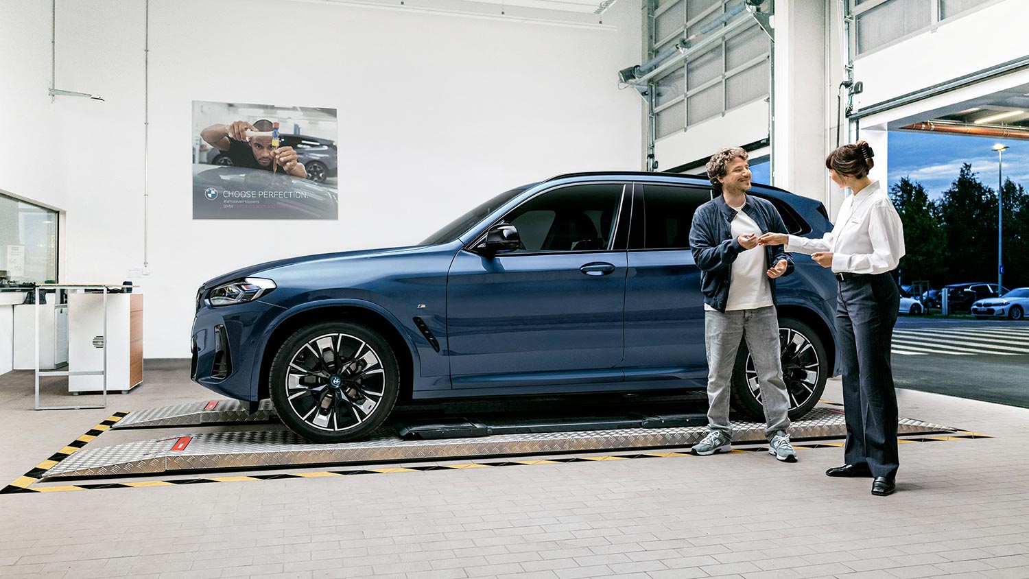 Fahrzeugübergabe eines blauen BMW iX3 – persönlicher Service im Autohaus BMW Köhler in Karlstadt
