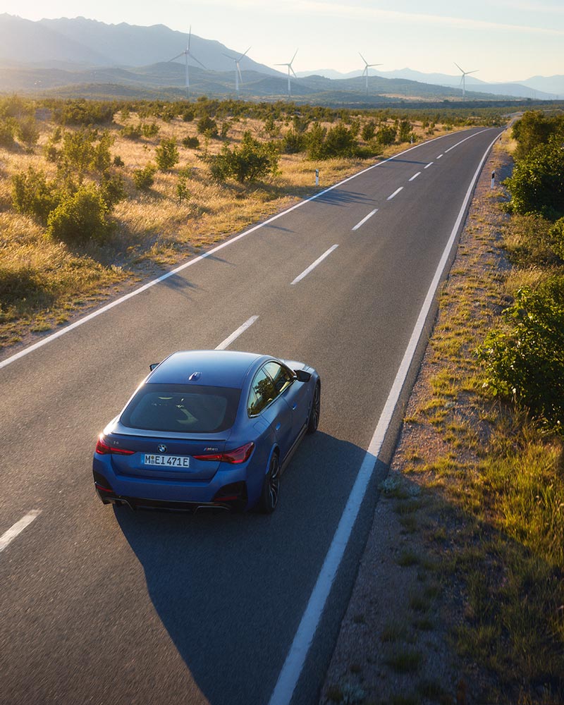 BMW i4 fährt durch eine malerische Landschaft – Freiheit und Fahrspaß im Autohaus BMW Köhler in Karlstadt