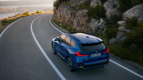 BMW iX1 fährt auf einer kurvenreichen Bergstraße – Agilität und Kontrolle im Autohaus BMW Köhler in Karlstadt