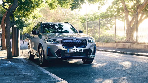 BMW iX3 beim laden in einer einer grünen Allee – Fahrfreude pur mit BMW Köhler in Karlstadt