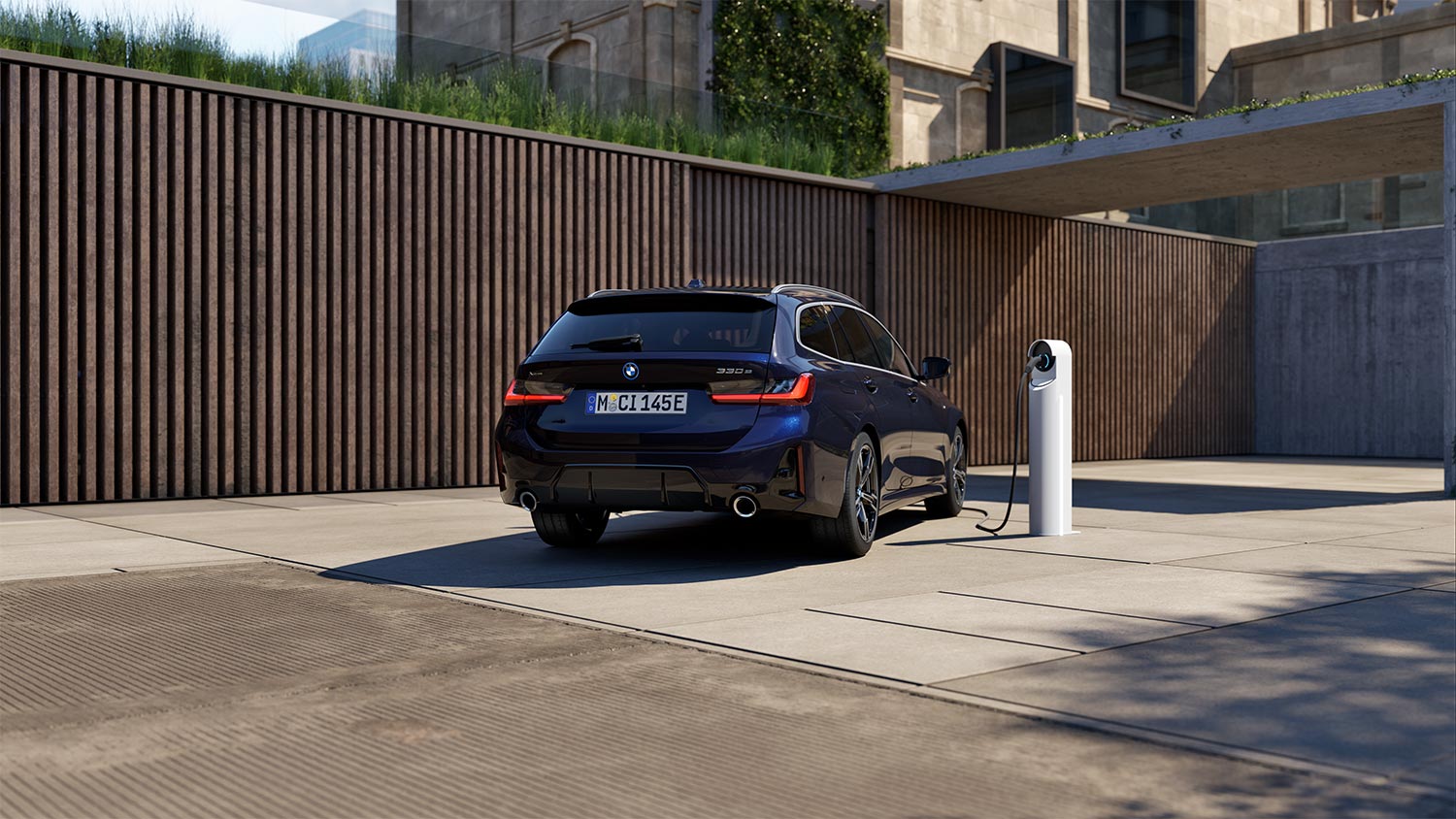 BMW 3er Touring in einer Wohnsiedlung an einer Ladesäule – Flexibilität und Fortschritt mit BMW Köhler in Karlstadt