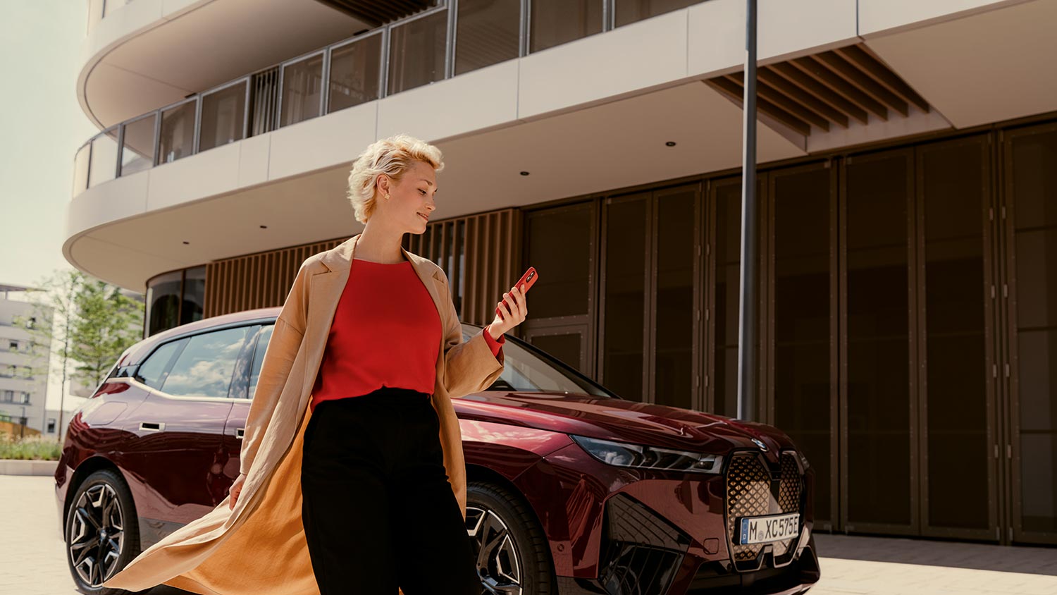 Frau mit Einkaufstüten vor einem roten BMW – Lifestyle und Fahrfreude mit BMW Köhler in Karlstadt