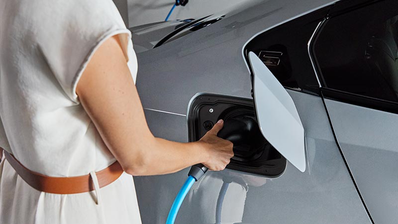 Frau beim Laden eines BMW-Elektrofahrzeugs – Zukunftsorientiert im Autohaus BMW Köhler in Karlstadt.