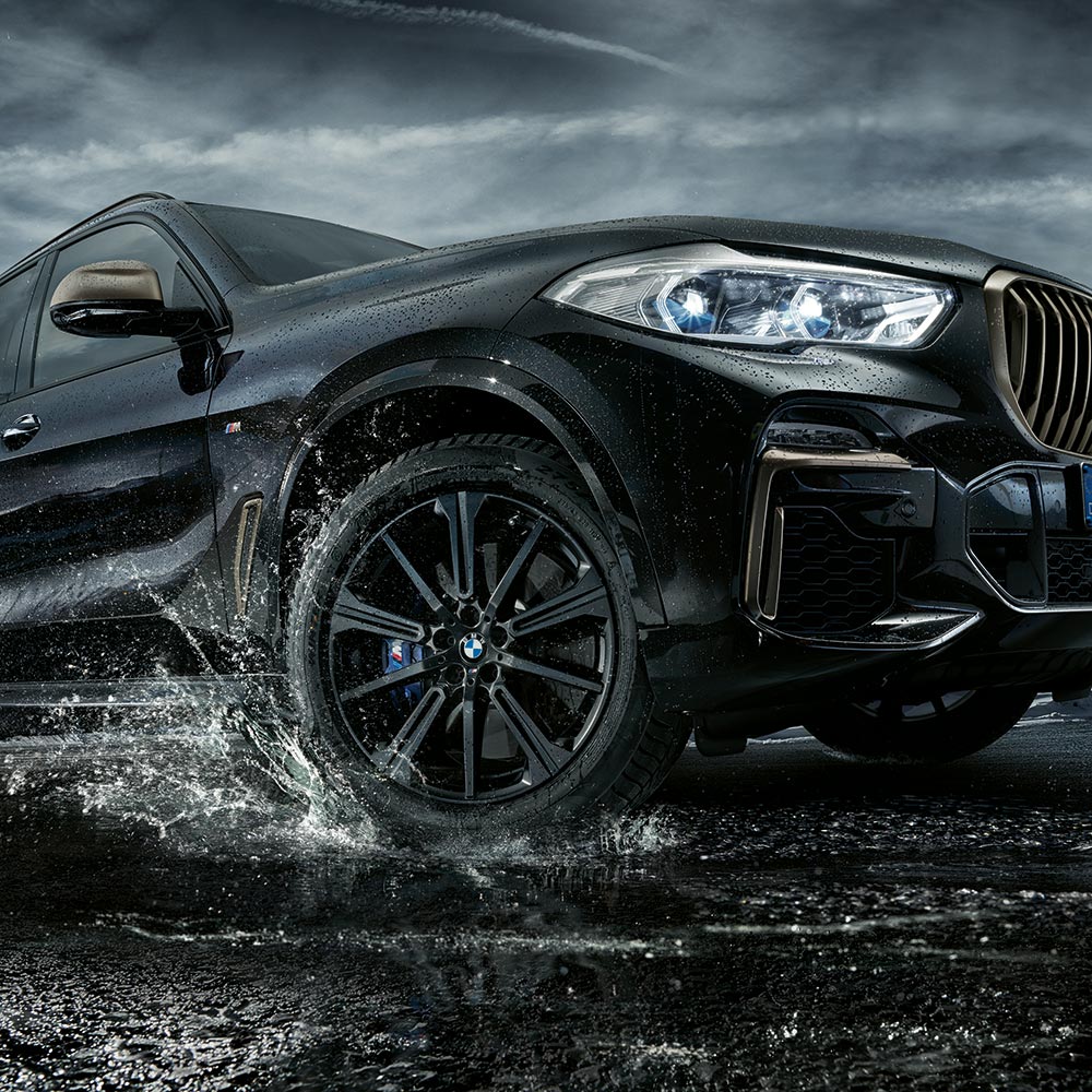 BMW X5 M50d in Aktion auf nasser Straße – stilvoll und leistungsstark im Autohaus BMW Köhler in Karlstadt.