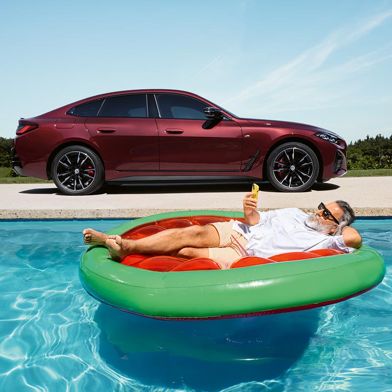 Frau entspannt im Pool mit einem BMW 4er Gran Coupé im Hintergrund – Komfort und Stil im Autohaus BMW Köhler in Karlstadt