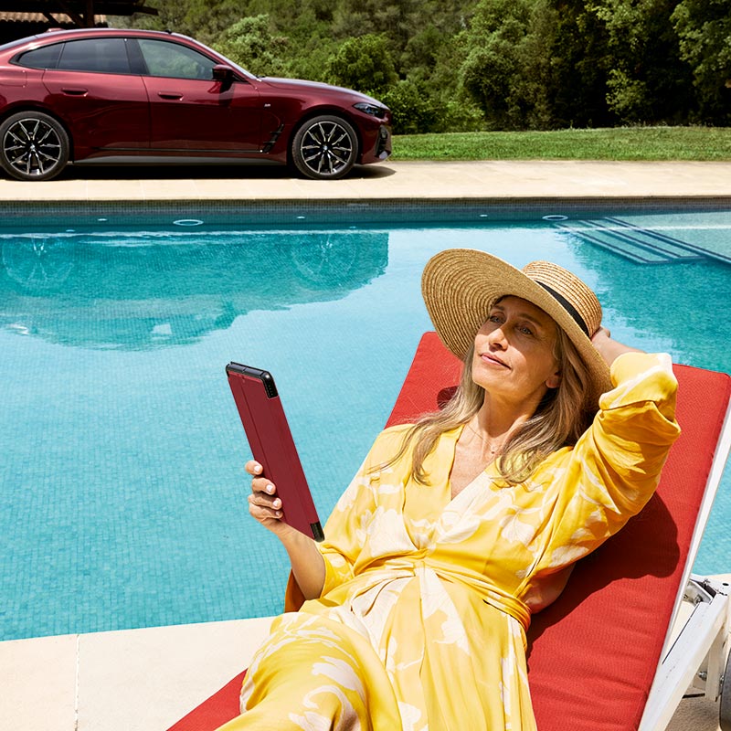 Frau in gelbem Kleid am Pool mit einem BMW im Hintergrund – Luxus und Fahrfreude im Autohaus BMW Köhler in Karlstadt