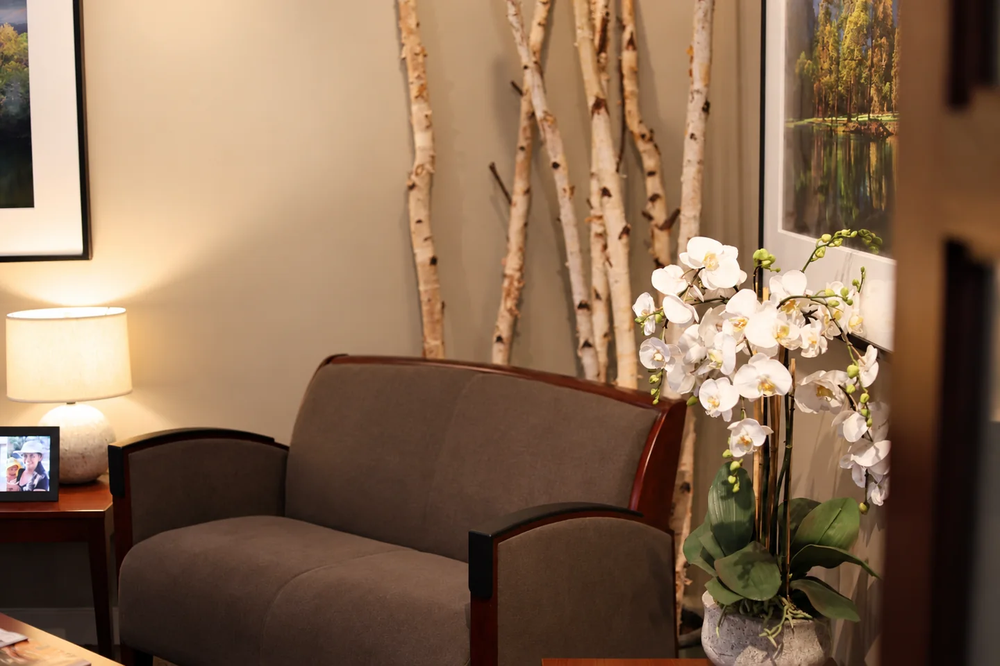 Waiting area at Palo Alto Oral Health with upholstered seating, orchids and framed photographs