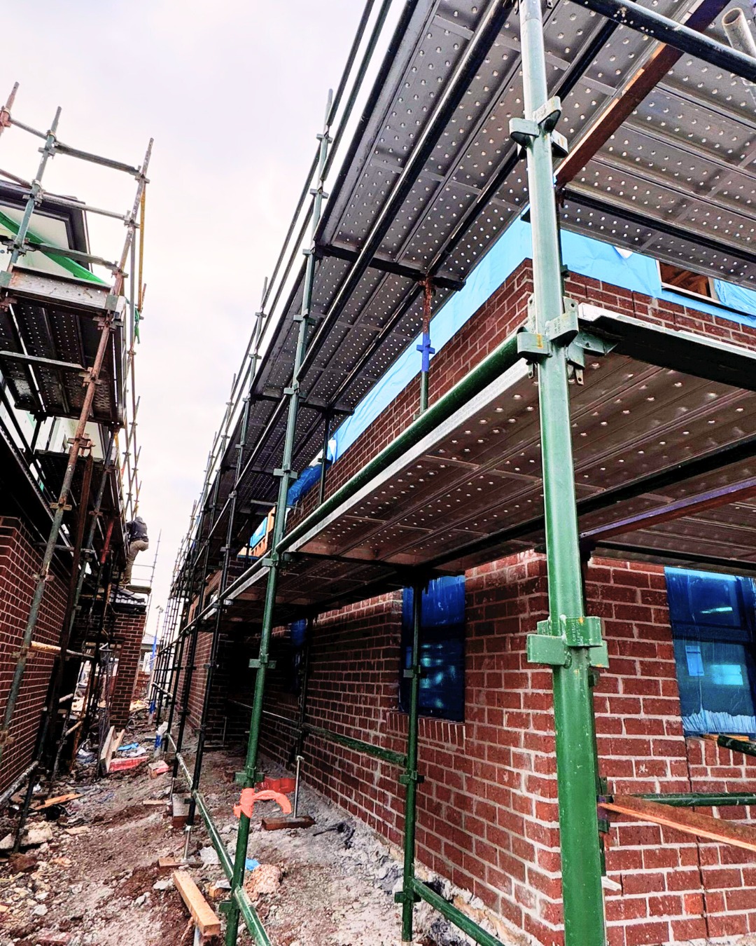 Close-up of a worker welding, creating a vibrant display of orange sparks against a blurred outdoor background