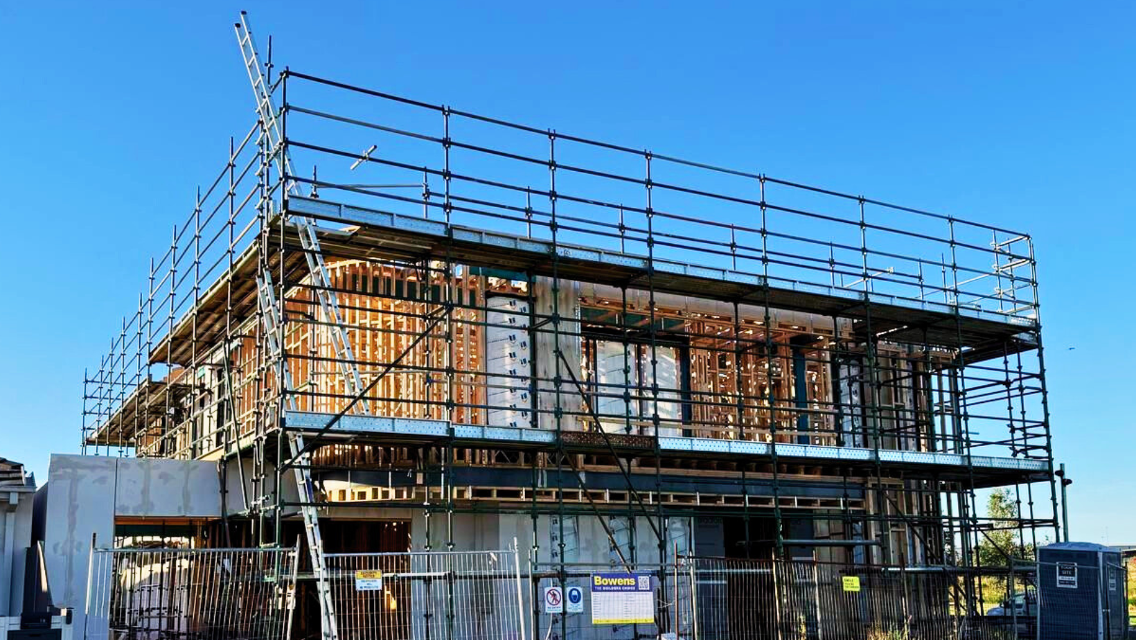 A construction worker wearing a yellow hard hat and glasses