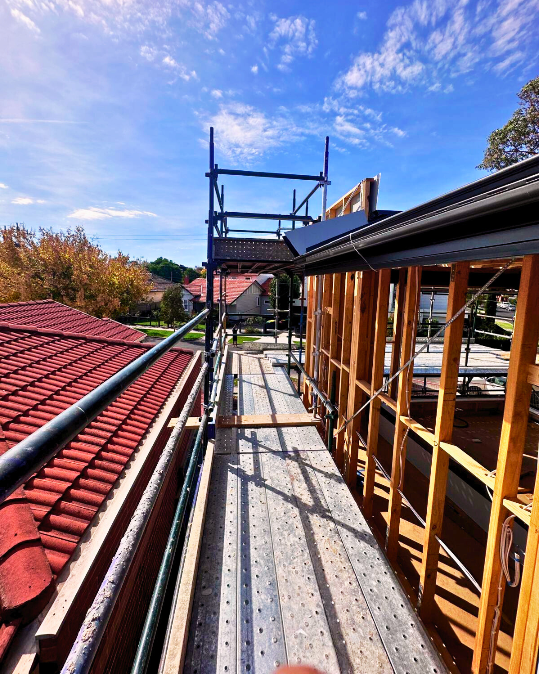 Construction workers are installing scaffolding working top warehouse building structure