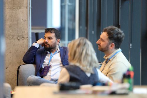 A group of professionals engaged in a business discussion in a modern office setting, representing collaboration and leadership among CEO Moments members