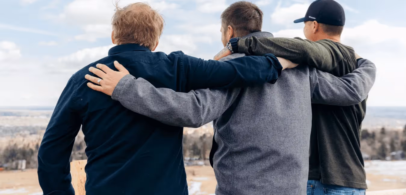 Three men on each others shoulder in outdoor looking afar