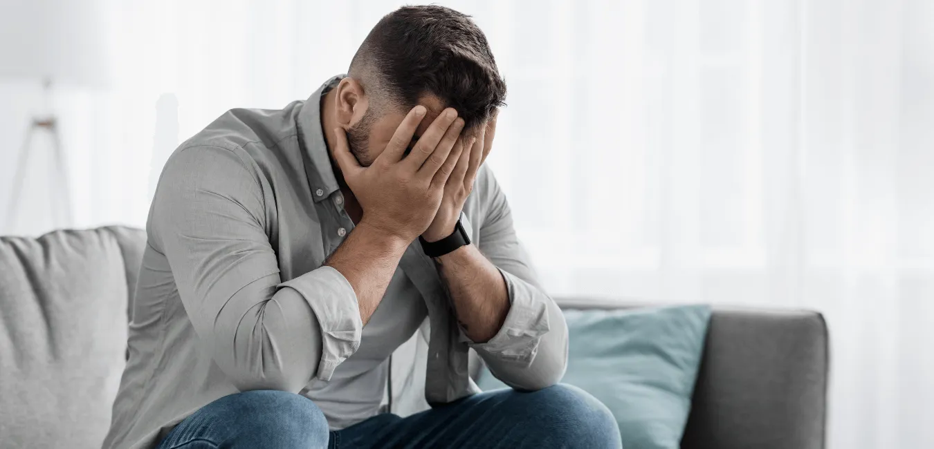 Man sitting on couch looking worried