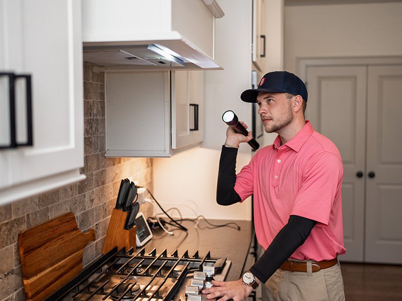 pest tech inspecting kitchen
