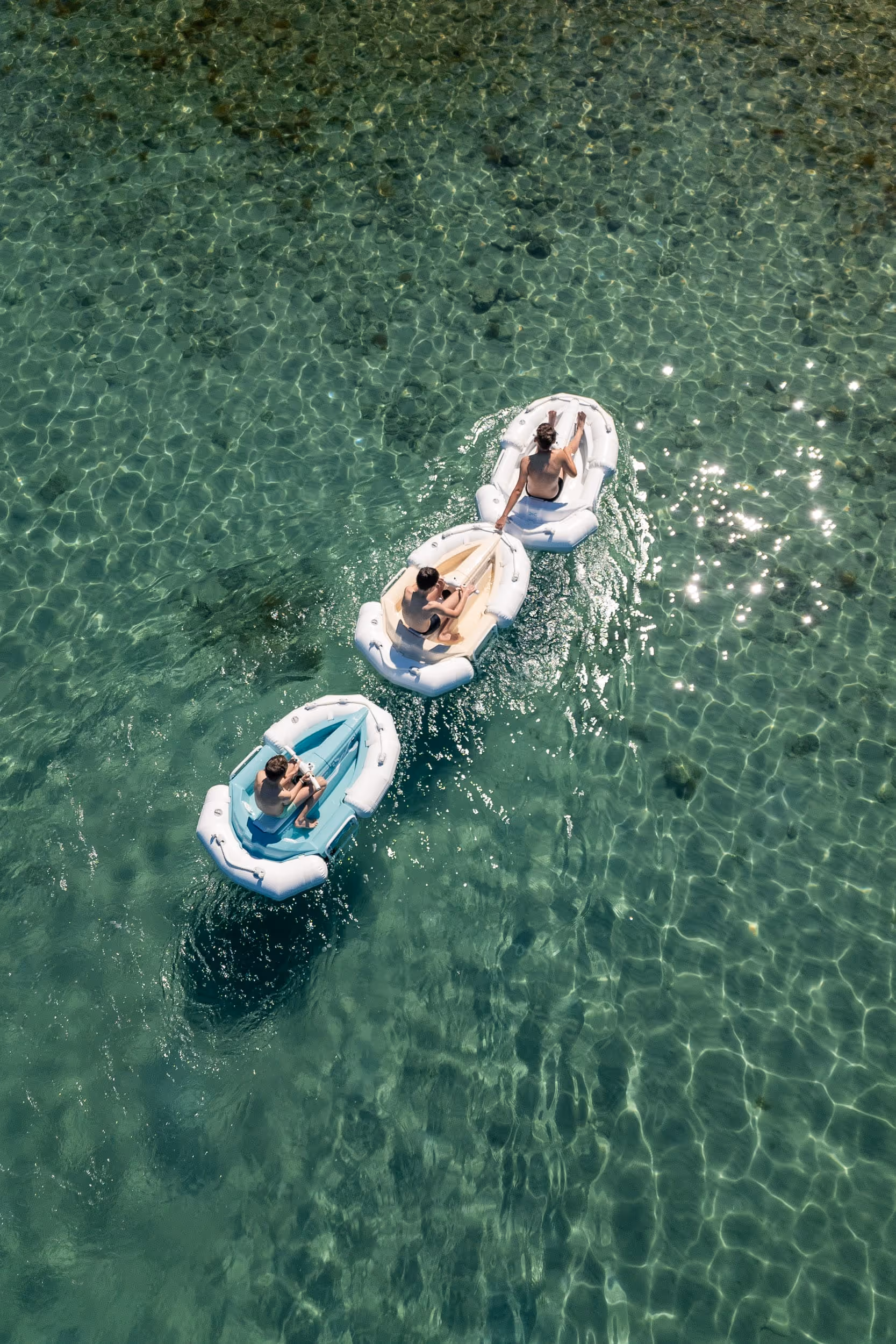 Drone shots of 3 Darth Craft watercrafts floating in a clear water one behind another