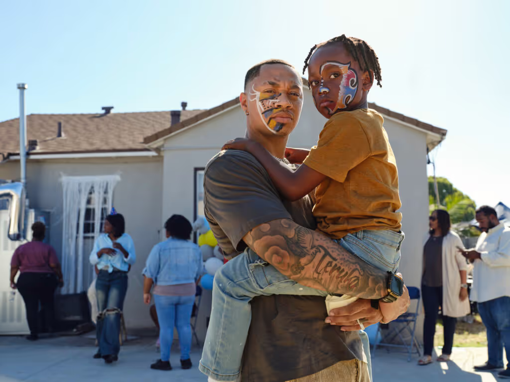 a man holding a child with face paint on