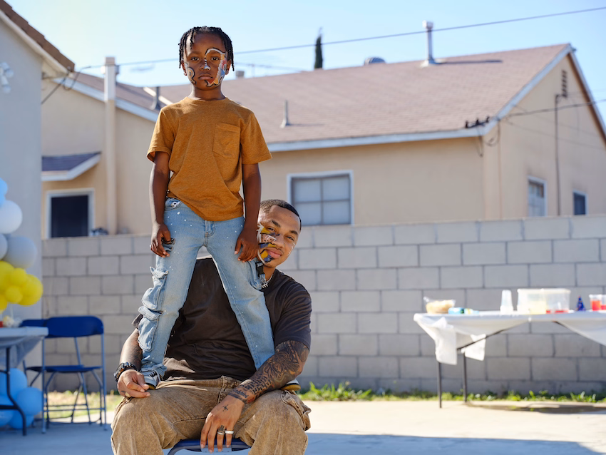 a man holding a child on his shoulders