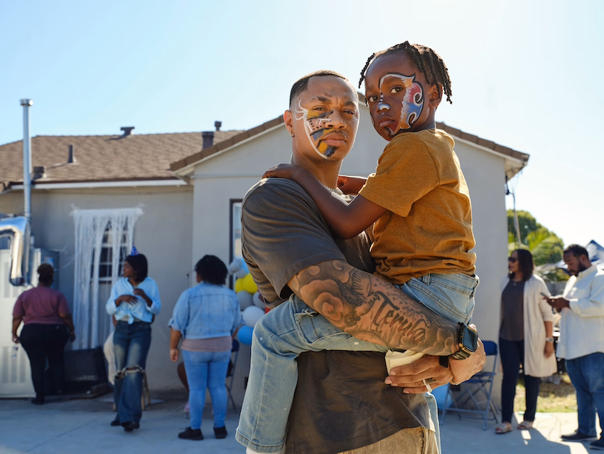 a man holding a child with face paint on