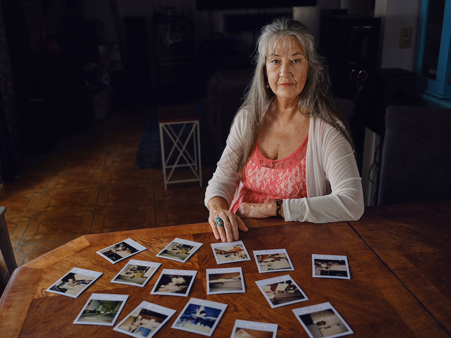 a woman sitting at a table with pictures on it