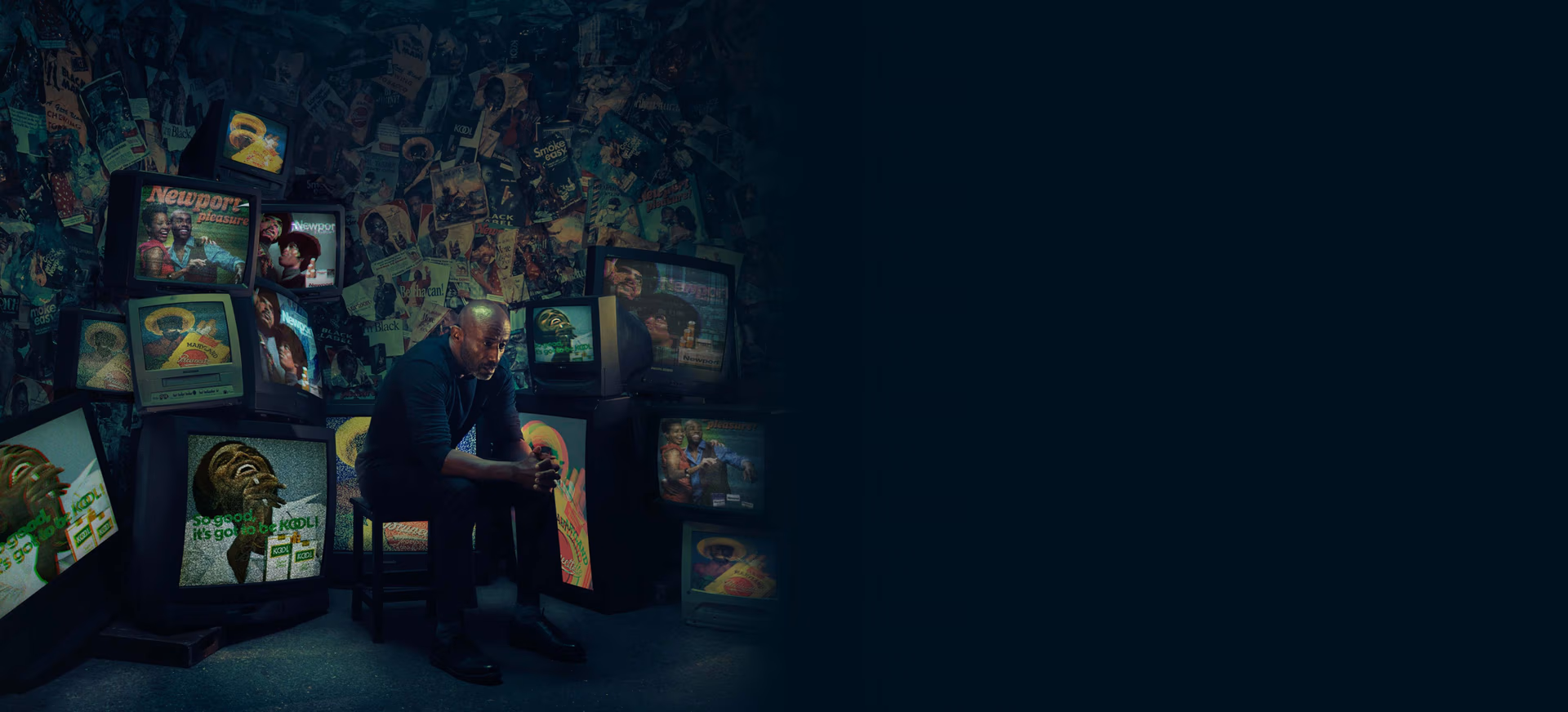 a man sitting in front of televisions