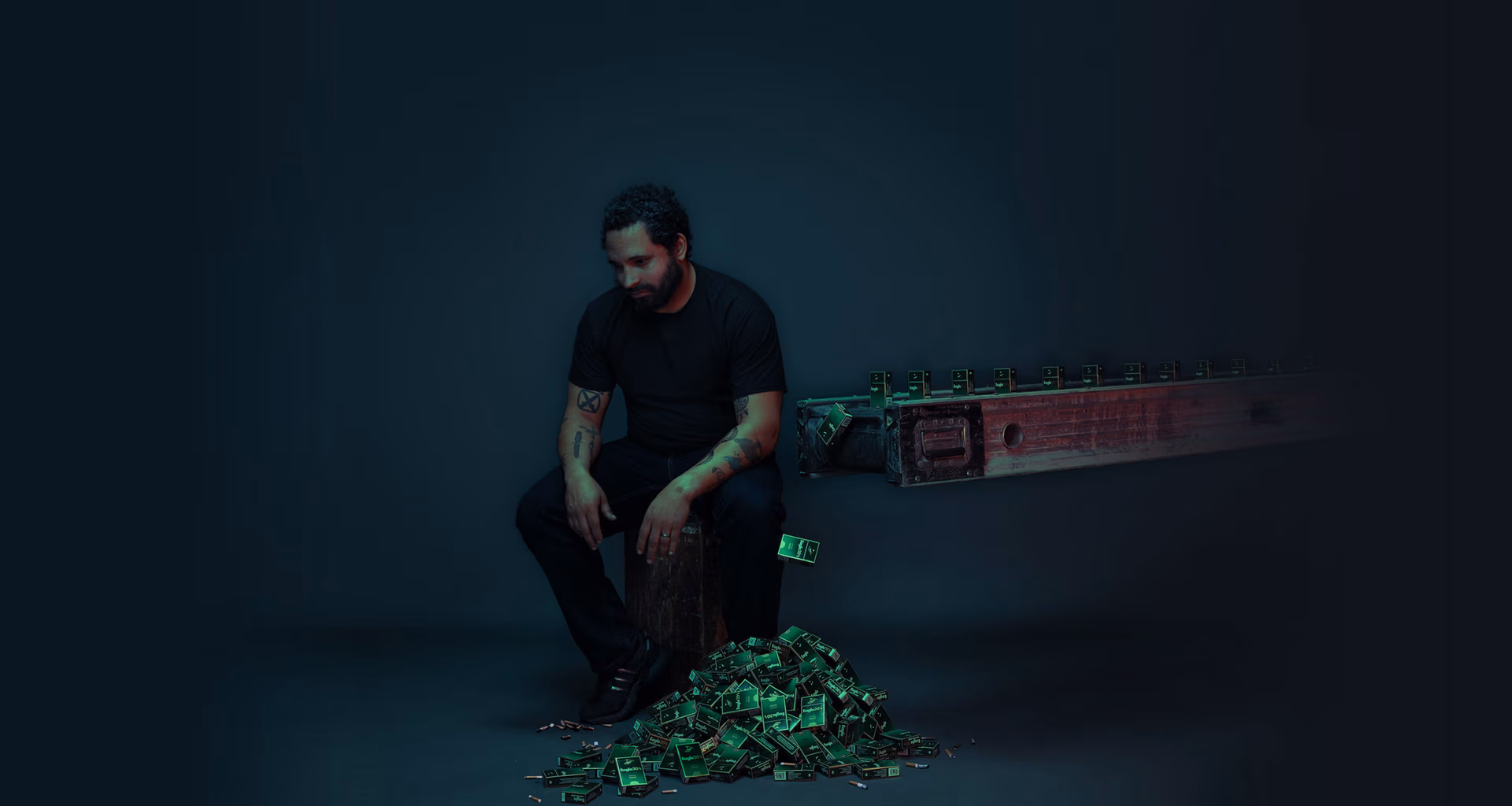 a man sitting on a box with a pile of green objects