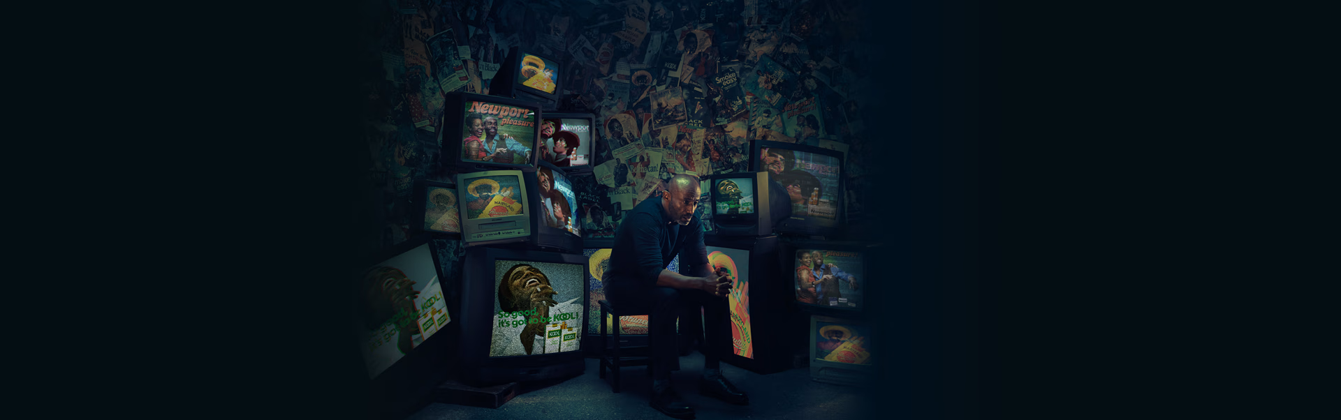 a man sitting in a chair surrounded by televisions