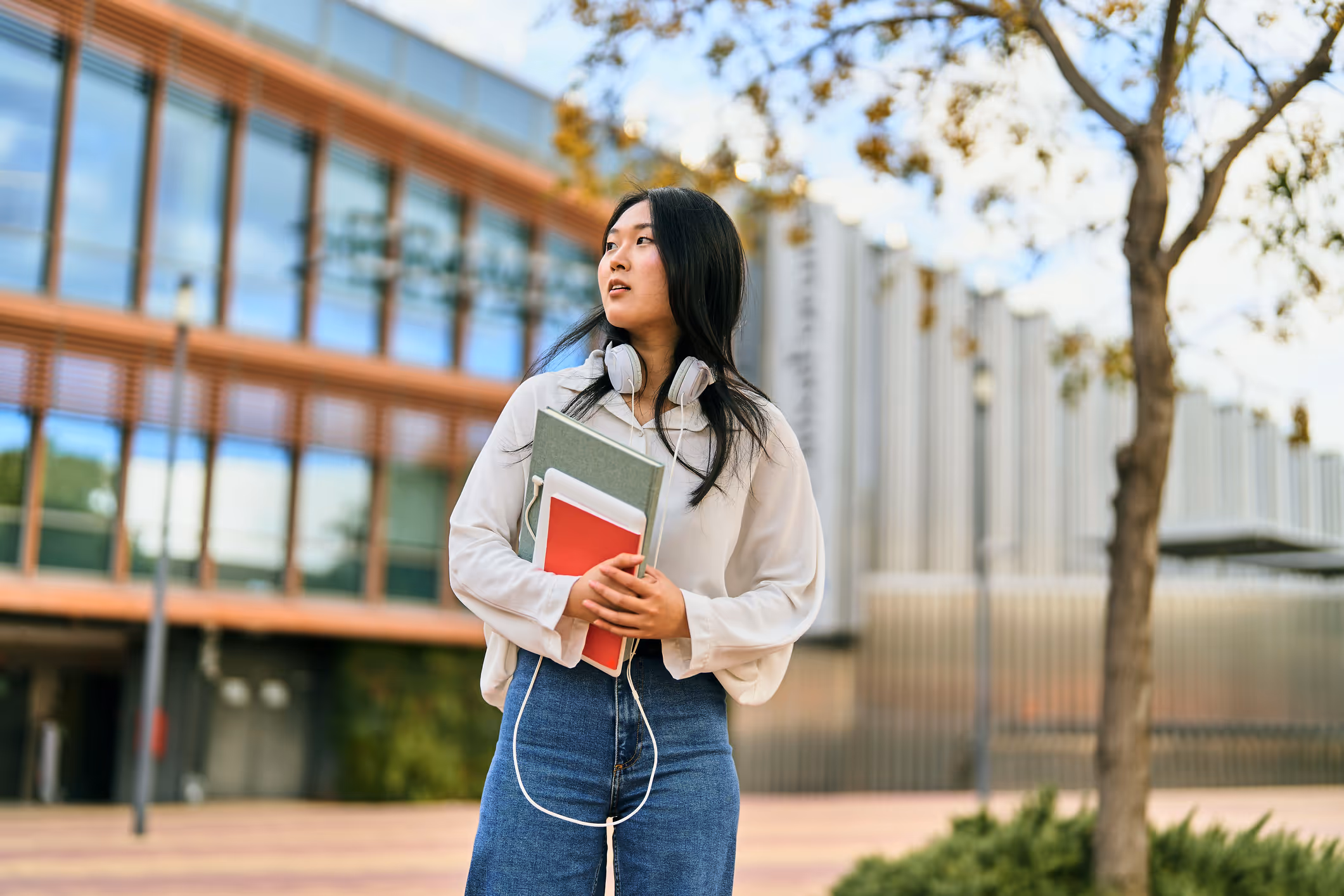 a woman holding books and headphones