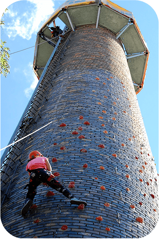 Girl wall climbing on an old factory chimney