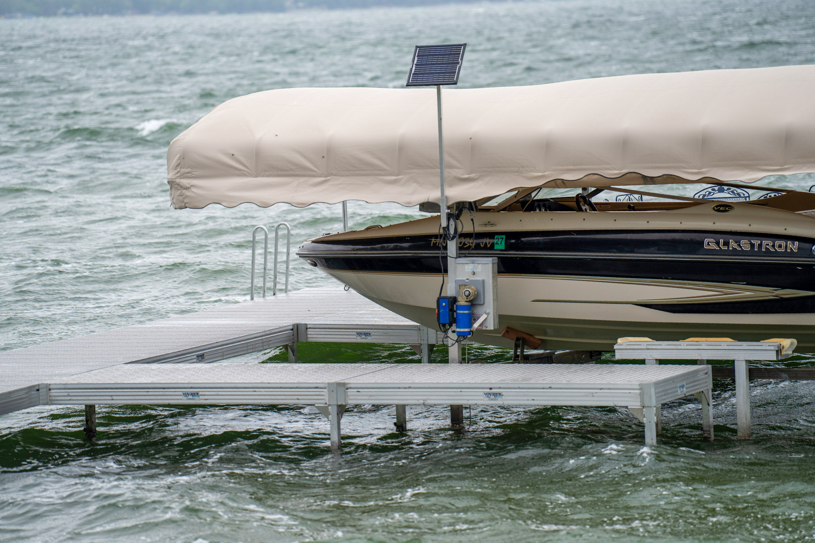 A boat securely situated on a lift protected from heavy waves