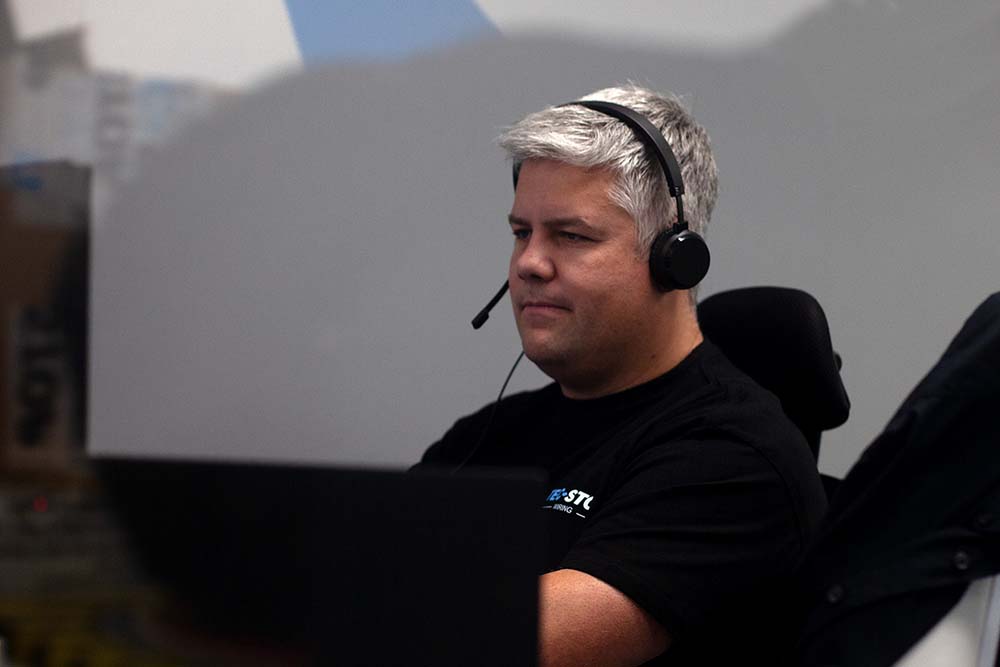 Tec-Stop team member wearing a headset during a project call, working through technical requirements and proposal details with a client.