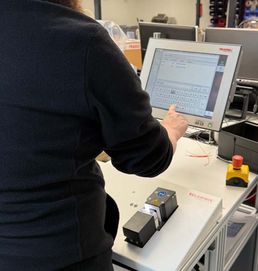 Tec-Stop technician using a Telsonic ultrasonic welding machine with digital controls to ensure precise, reliable electrical connections.