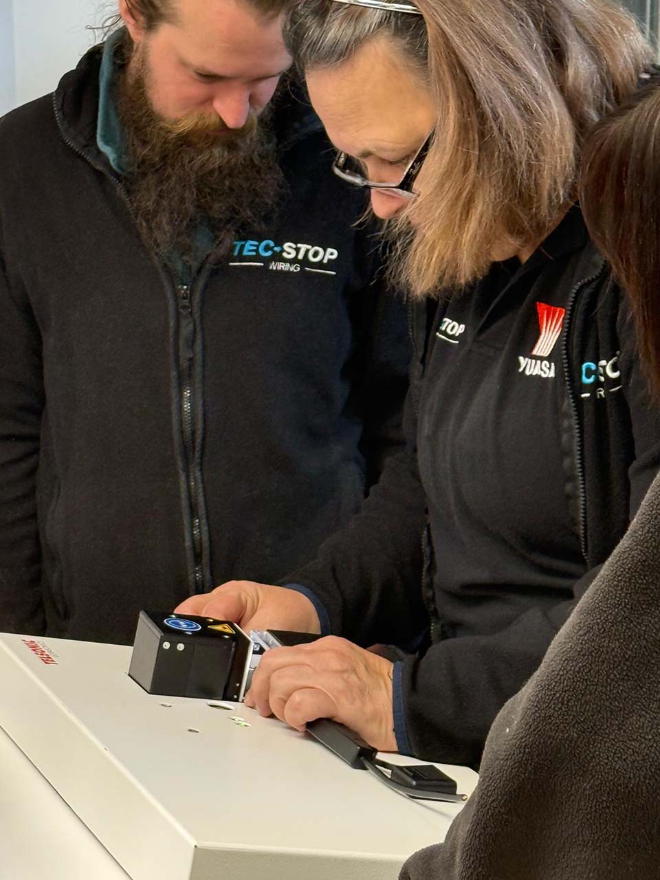 Tec-Stop team demonstrating ultrasonic welding equipment for high-quality electrical connections and cable assemblies.