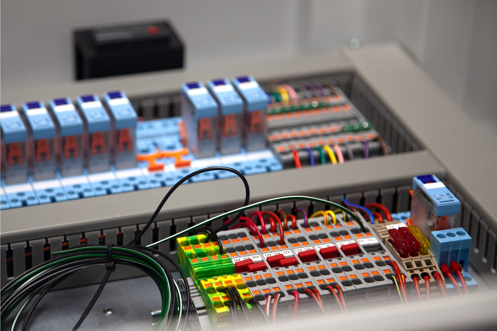 Close-up of a professionally wired bespoke electrical control panel featuring terminal blocks, relays, and neatly organised wiring. Image showcases the precision, quality, and complexity of Tec-Stop’s custom-built industrial control systems designed for UK manufacturing and automation.