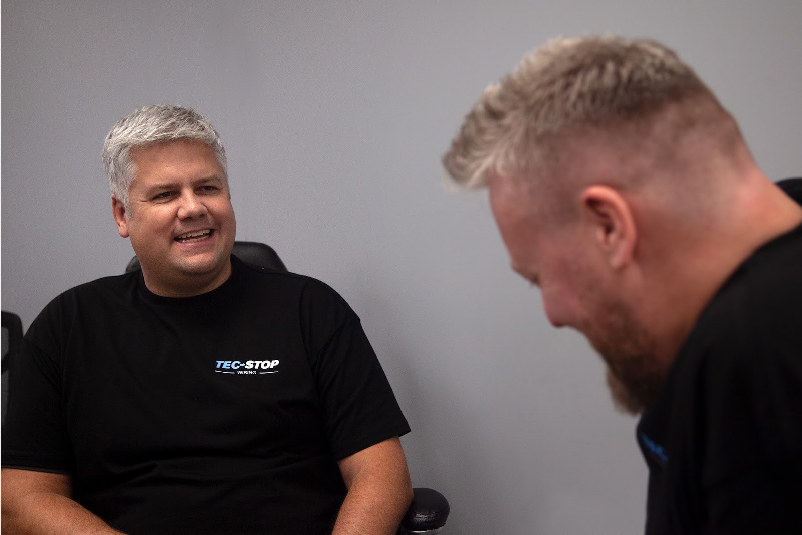 Tec-Stop team members collaborating in a relaxed meeting, reflecting a positive and proactive company culture