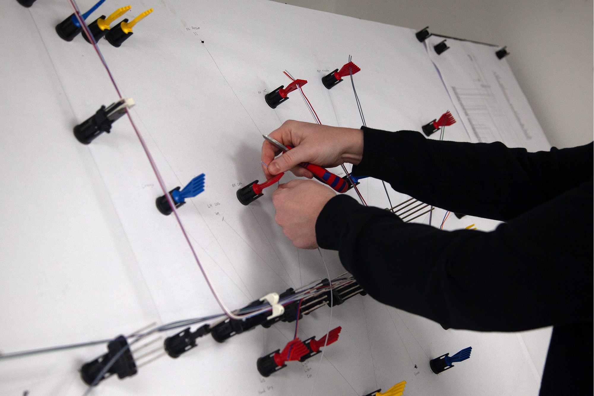 Wiring loom routed on a pegboard layout for accurate, repeatable harness production