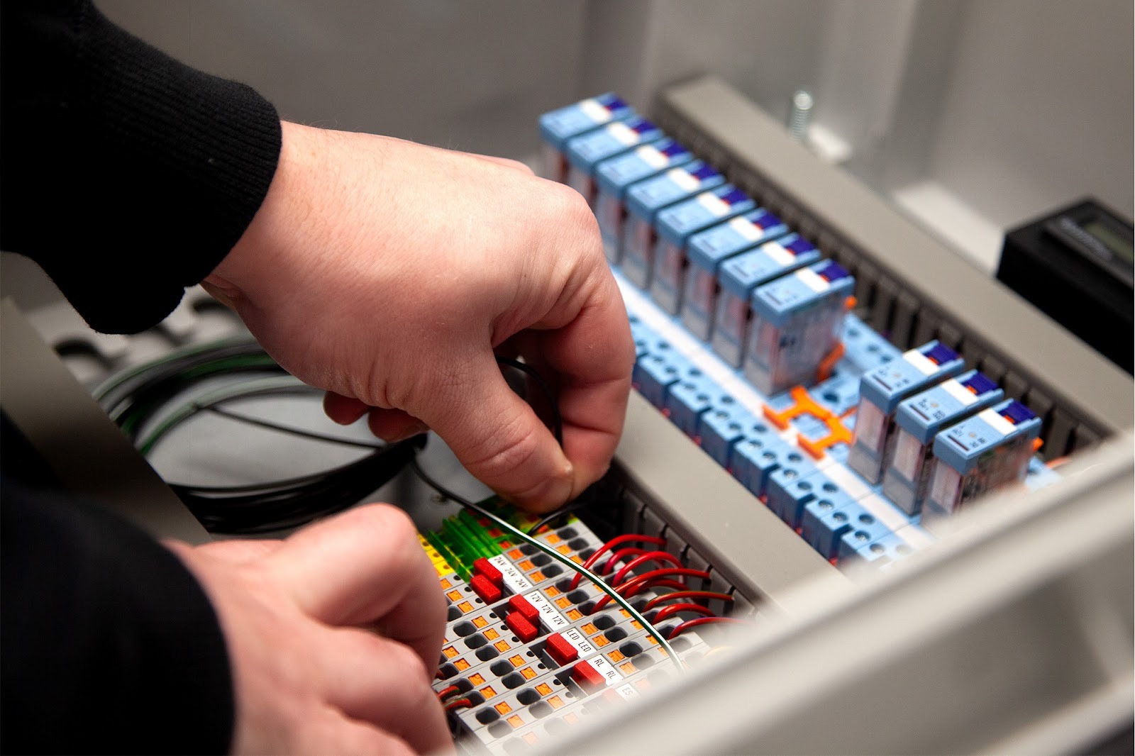Technician completing wiring terminations and identification within an industrial control panel build