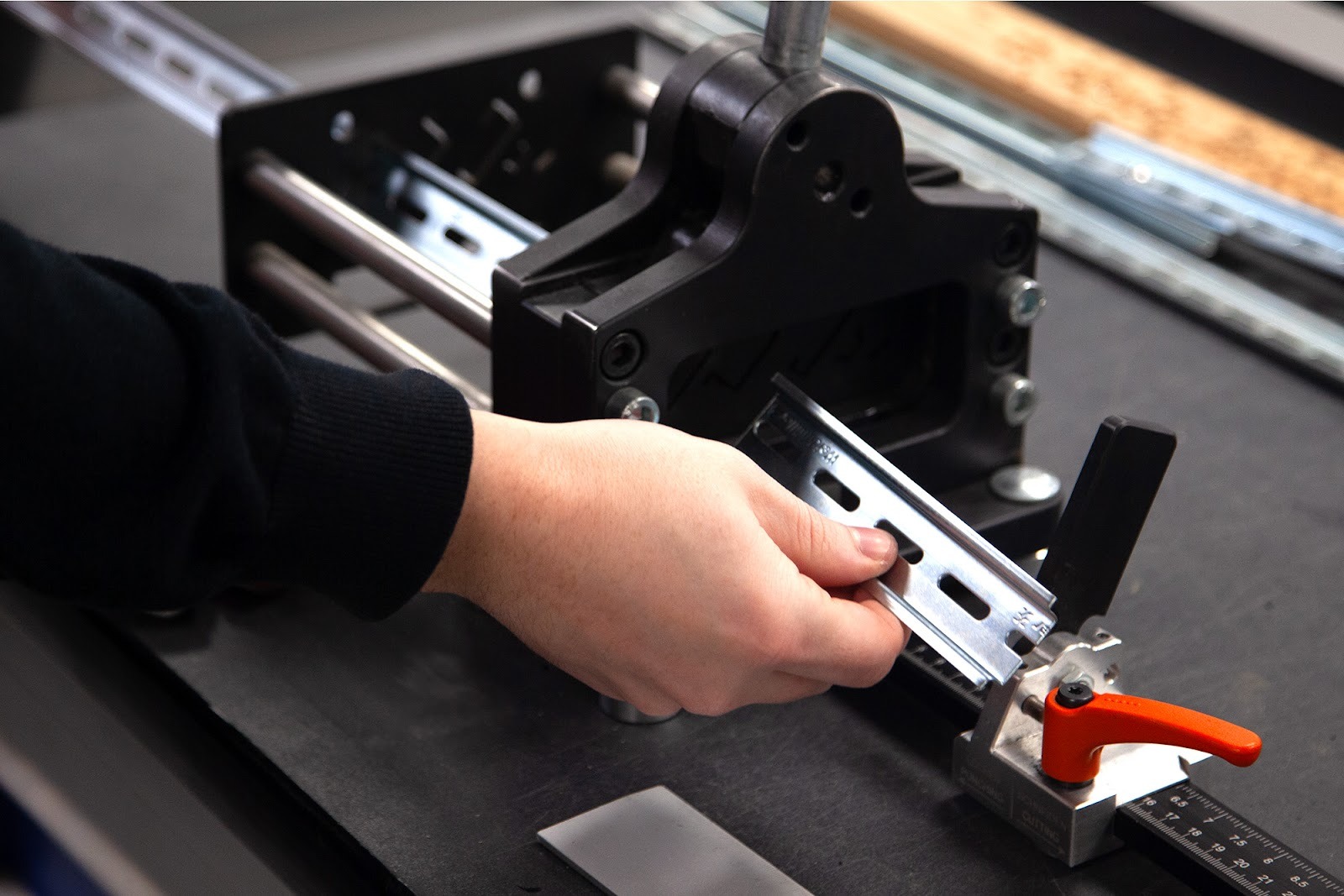 Technician preparing metal components using fabrication tooling to support OEM bracket and mounting solutions