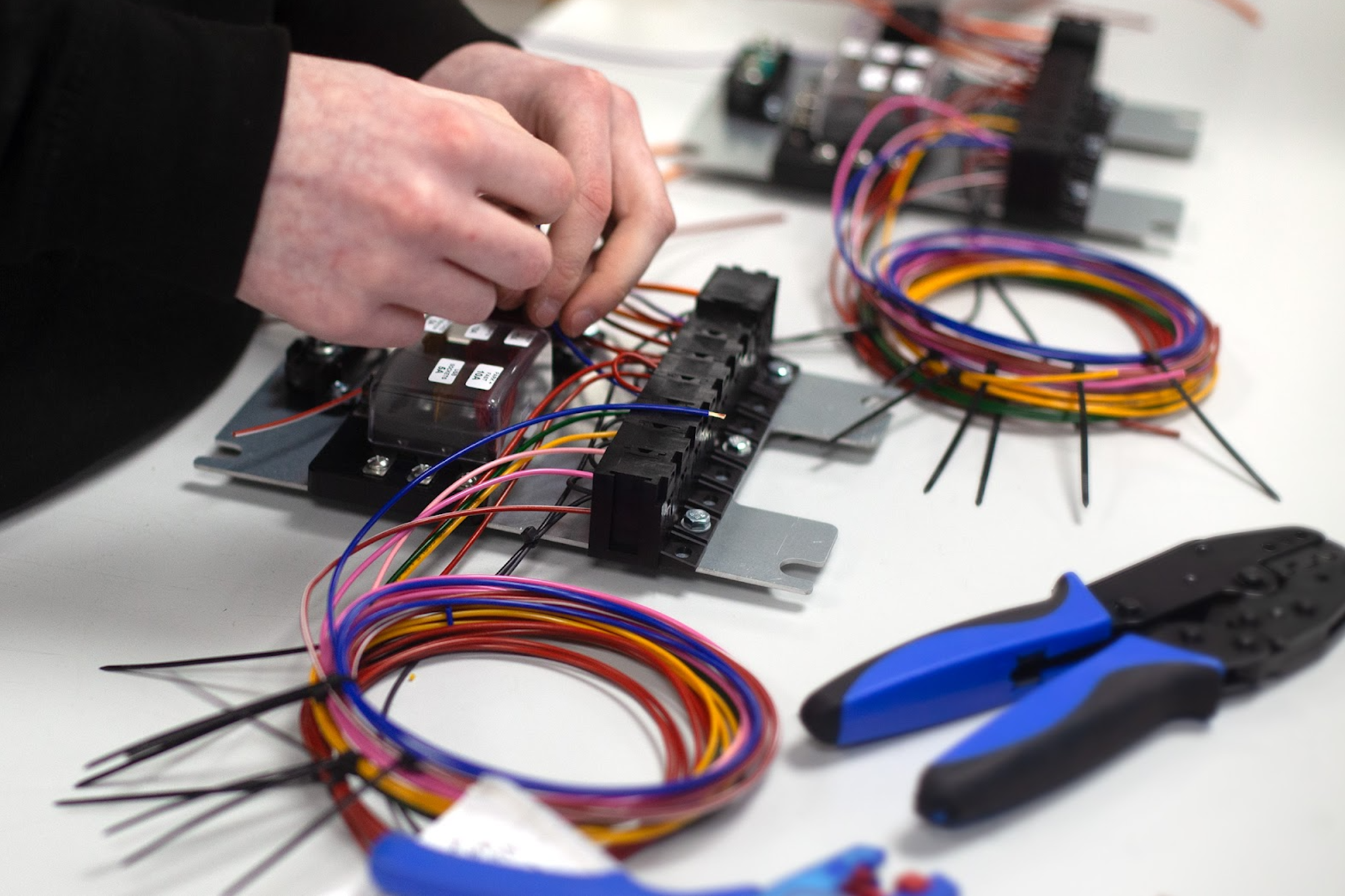 Engineer assembling and verifying wiring connections for OEM electrical systems