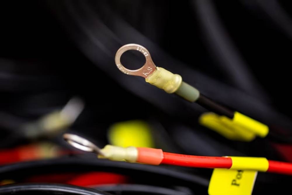 Close-up of labelled ring terminals used in automotive wiring harness assemblies