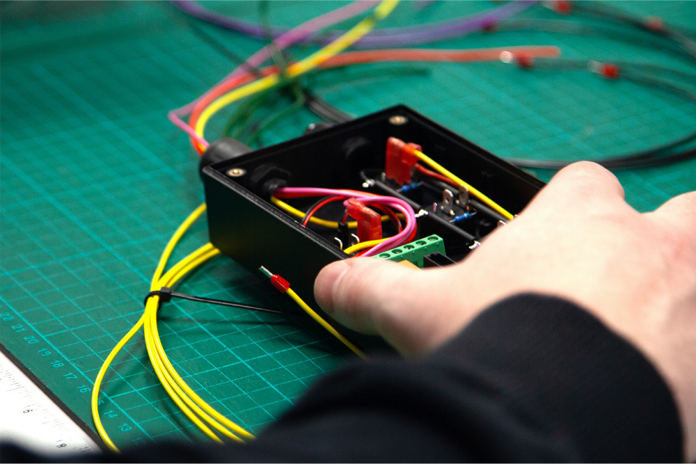 Technician assembling and checking a bespoke wire harness during manufacture at Tec-Stop
