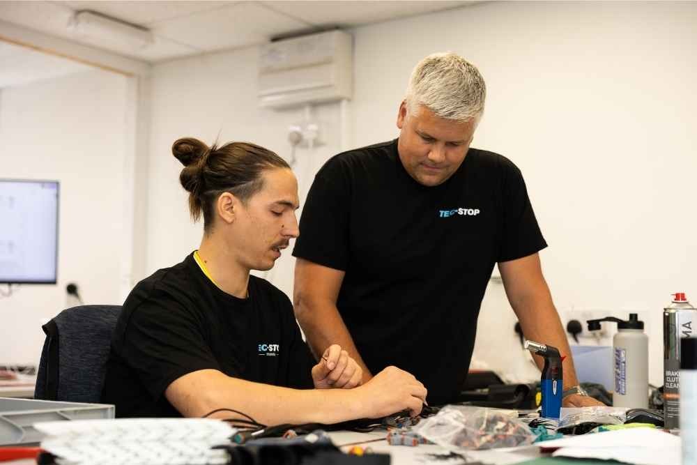 Tec-Stop technicians assembling electrical components at a workbench