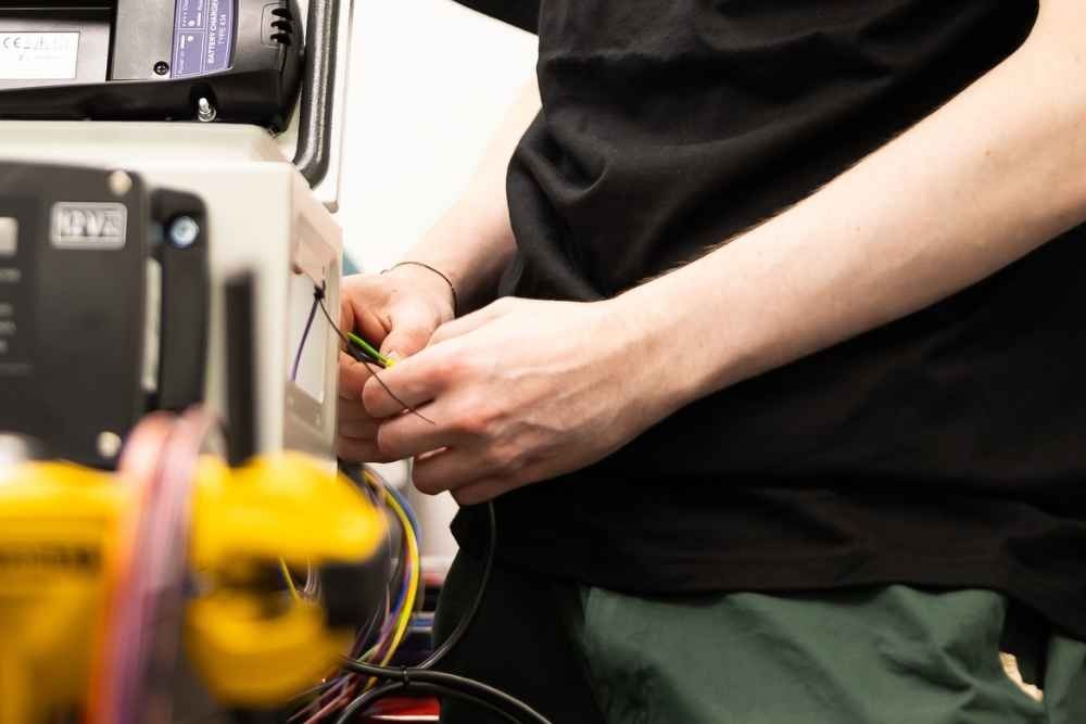 Technician working on wiring and electrical components during assembly